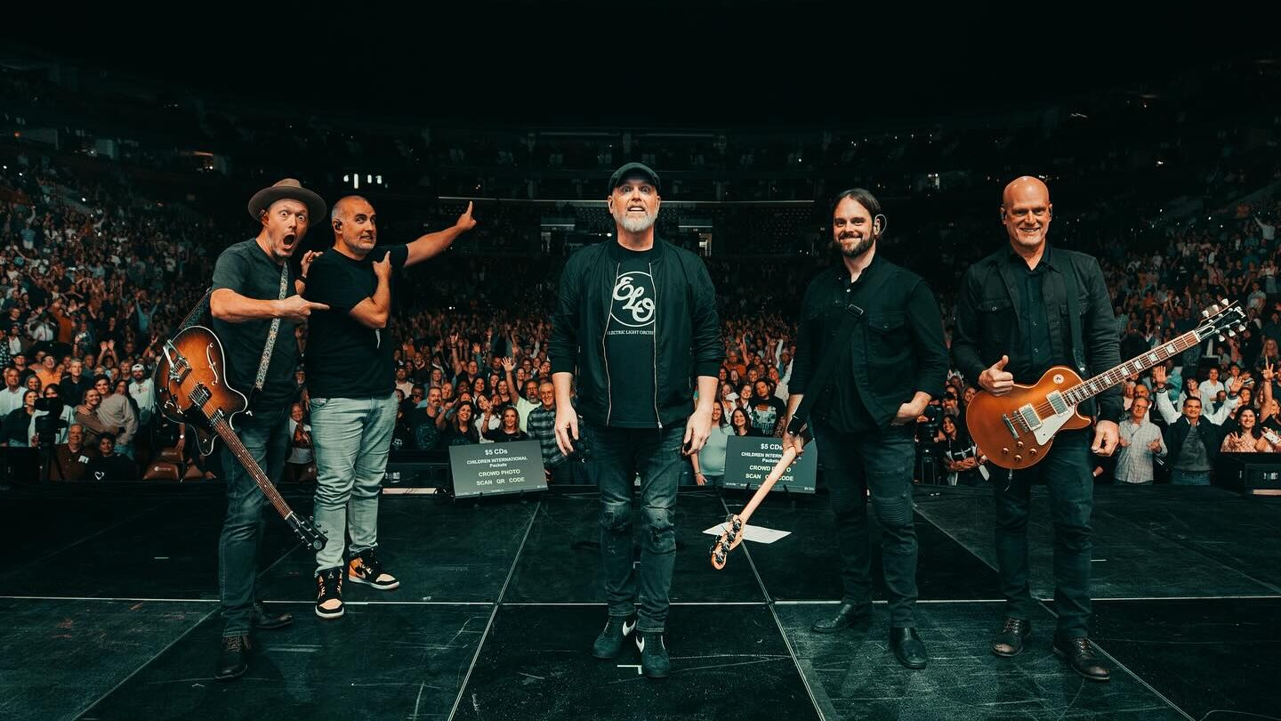 MercyMe standing together on stage in front of a concert audience